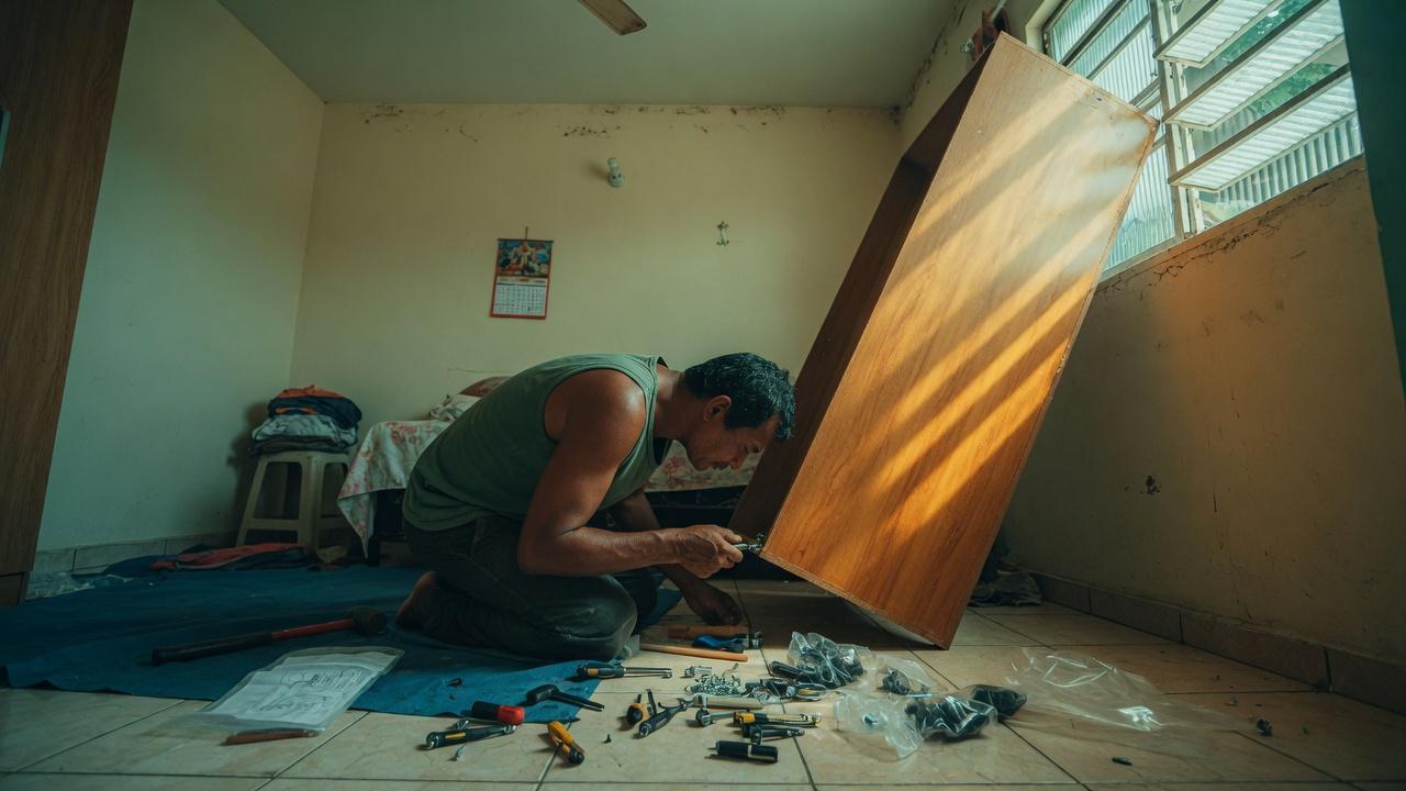 Montador de móveis em Manaus encaixando painel de guarda-roupa no quarto